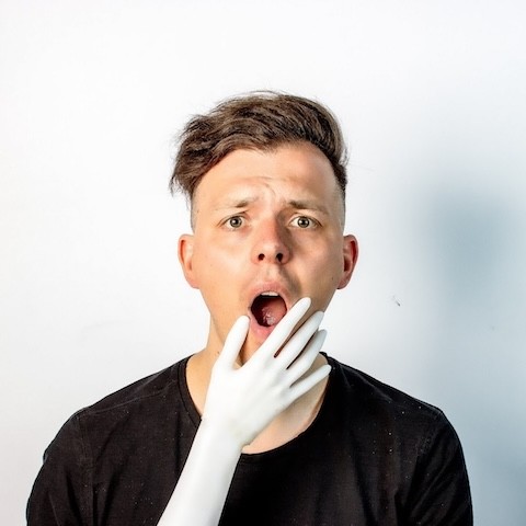 Foto von Moritz Simon Geist, vor dessen Gesicht sich eine künstliche Hand befindet