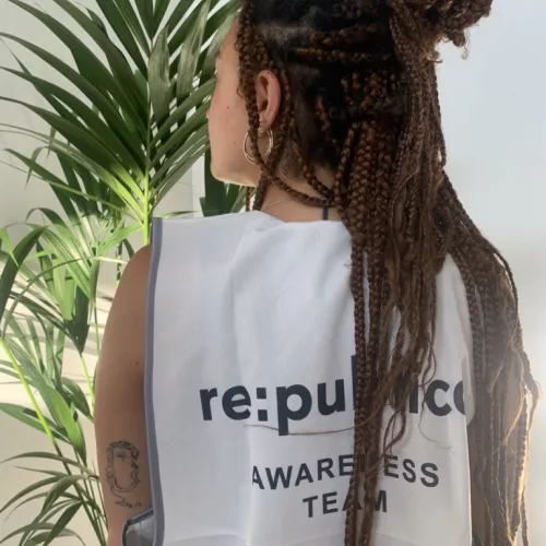 Bild zeigt den Rücken einer Person, die eine weiße Awareness Weste trägt auf der 're: publica - Awareness Team' steht