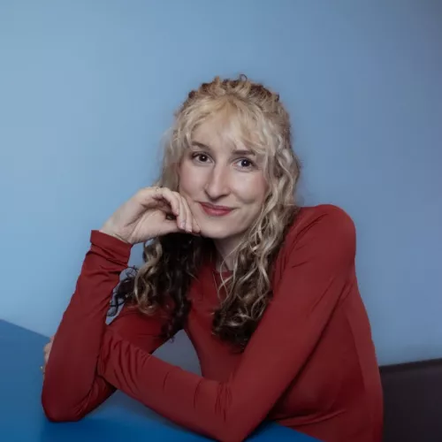 Rosalie lehnt an einem blauen Tresen