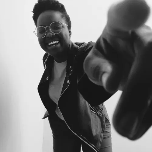 Black and white image of Puno smiling to camera - Head to knee shot 