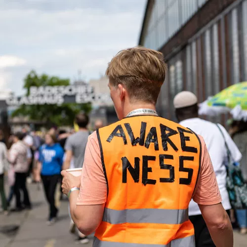 Person von hinten, trägt eine Weste mit der Aufschrift "Awareness"