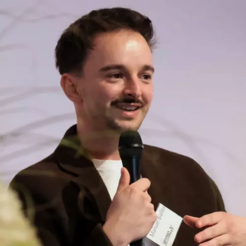 Manuel Biallas hält ein Mikrofon in der Hand