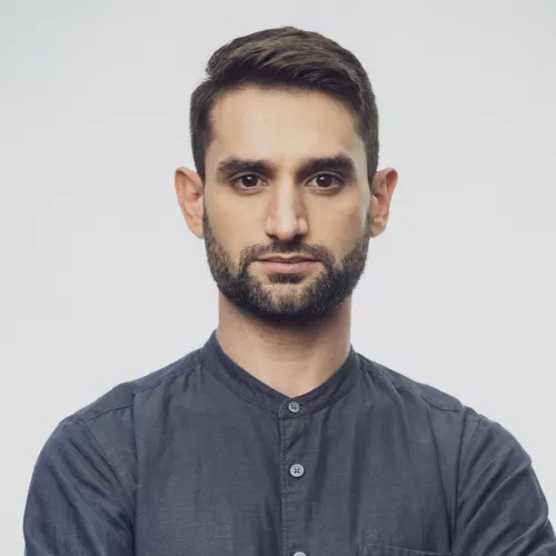 Benjamin Fischer with a navy blue shirt in front of a white background