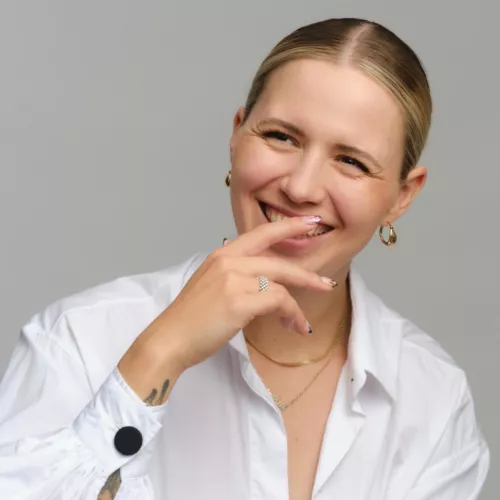 Frau lachend mit leicht vorgehaltener Hand