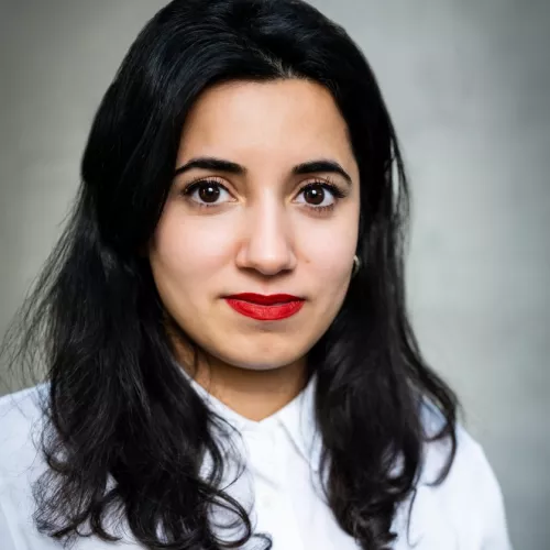 Portrait von Misbah Khan. Sie schaut direkt in die Kamera und trägt ein weißes Oberteil.
