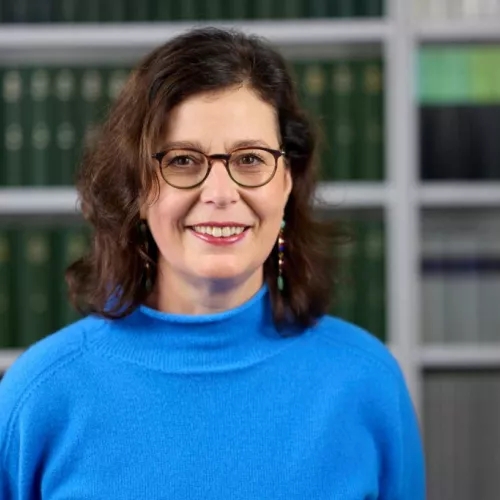 Das Bild zeigt Silke Schicktanz als dunkelhaarige Frau mit Brille in einem hellblauen Pullover