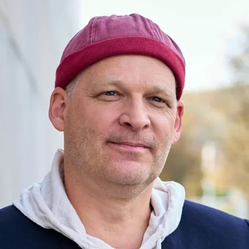 Portraitfoto von Sascha Verlan mit Kappe