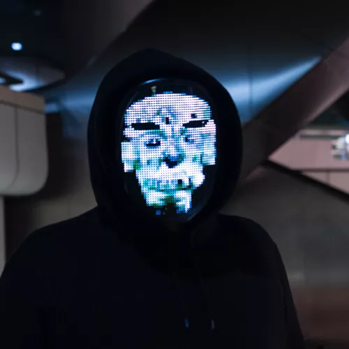 Picture of a man wearing a black hoodie and a LCD mask.