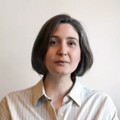 Katja Schlangen mit einer kinnlangen Bobfrisur und einem hellen Hemd