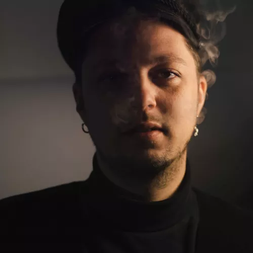 Portrait eines jungen Menschen mit Hut und Rauch